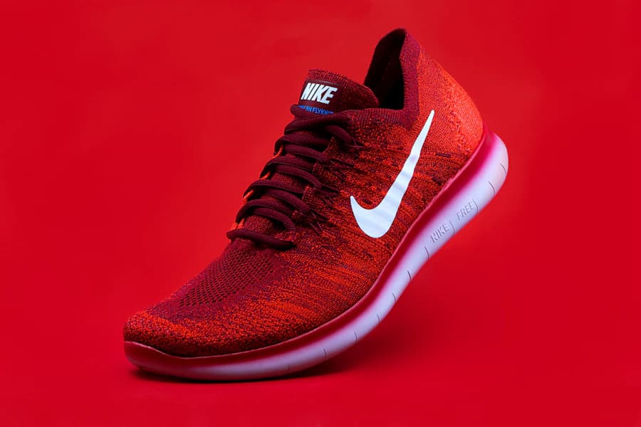 A red Nike sneaker photographed against a red background